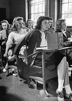 black and white photograph of people sitting at desks