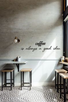 the interior of a coffee shop with tables and stools