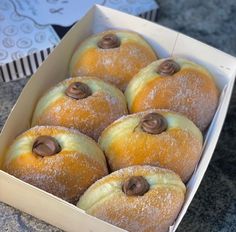 there are many donuts in the box on the table