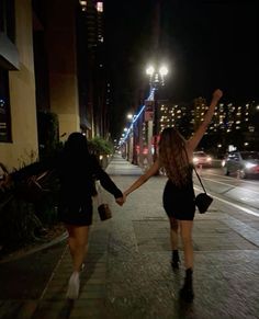 two women walking down the street holding hands