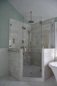 a white bath tub sitting next to a walk in shower