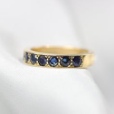 "Stunning sapphire half eternity ring. Wide and full of presence and set with beautiful natural gemstones. Handmade by an inspired jewelry artist team with decades of experience in the craft of jewelry making. Each gemstone, each diamond is carefully picked. Using only the finest raw materials and the highest industry standard in manufacturing, design and finish. Ring Features: Set with 2.75 mm round facet cut Natural Sapphires with a perfect deep Medium-blue color. This eternity ring is 3.5mm w Sapphire Half Eternity Ring For Anniversary, Sapphire Anniversary Ring Channel Set, Channel Set Sapphire Jewelry, Channel Set Sapphire Ring For Anniversary, Lab-created Sapphire Ring With Channel Set, Fine Jewelry Sapphire Half Eternity Ring, Sapphire Ring Channel Set As Gift, Sapphire Round Cut Half Eternity Ring, Channel Set Sapphire Ring As Gift