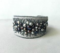 Bead embroidery cuff bracelet, freshwater pearl cuff Winter lace, statement beacelet,  bead embroidered bracelet, statement jewelry 62 pearls! This statement bracelet is stitched on light grey felt, I used freshwater pearls of different tones of greys - silver, gunmetal, silver peacock blues and greens, creams and whites as well. Some are big, some are the tiniest, some are smooth, some are rustic. They are embraced by tiny silver lined light grey rainbow seed beads. Bracelet is neatly backed with light grey Ultrasuede. The bracelet has beautiful curved shape, it is wider at front and more narrow at the ends. The width of the front part about 1 1/2 inches (3,9 cm). The inside diameter of this bracelet is about 2 1/2 inches (6,4 cm) but it can be adjusted bigger or smaller by slowly bending Handmade Luxury Pearl Bracelet, Beaded Cuff Jewelry Gift, Elegant Beaded Cuff Jewelry, Luxury Handmade Pearl Wedding Bracelet, Handmade Luxury Pearl Bracelet For Wedding, Luxury Handmade Pearl Bracelet For Wedding, Elegant Beaded Cuff Bracelets, Elegant Beaded Cuff Bracelet As Gift, Elegant Beaded Cuff Bracelet For Gift