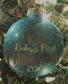 a baby's first christmas ornament hanging from a christmas tree