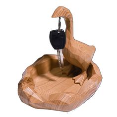 a car key holder made out of wood with a swan on it's back