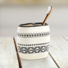 a toothbrush holder sitting on top of a wooden table