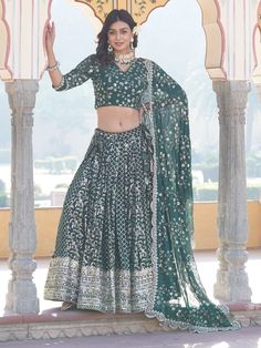 Step into the realm of timeless elegance with this stunning green jacquard lehenga adorned with intricate embroidered work and shimmering sequin detailing. Paired with a matching jacquard choli and a georgette dupatta, all featuring similar embellishments, this ensemble exudes opulence and grace. The lehenga, with its 3.5-meter flair and stitched up to 42 inches with can-can for added volume, offers a flattering silhouette that accentuates your curves beautifully.
The rich green hue of the lehen Jacquard Lehenga, Engagement Gown, Lehenga Crop Top, Lehenga Choli Wedding, Floral Lehenga, Party Wear Lehenga Choli, Reception Gown, Bollywood Lehenga, Georgette Dupatta