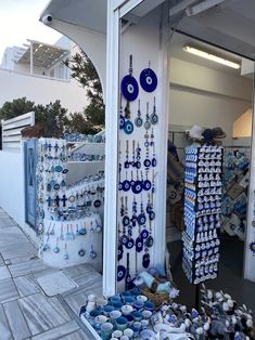 there are many blue and white items on display outside the storefront, including necklaces