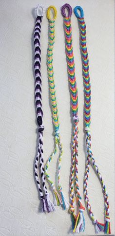 four different colored ropes are lined up on a white surface