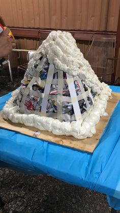 there is a cake made to look like a mountain on a table with blue cloth