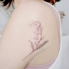 a close up of a woman's shoulder with a flower tattoo on her left arm