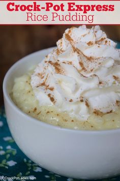 a close up of a bowl of food with whipped cream on top and the words crock pot express rice pudding