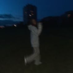 a blurry photo of a person holding a cell phone up to their ear in the dark