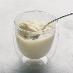 a glass bowl filled with ice cream on top of a table next to a spoon