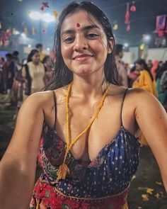 a woman in a colorful sari poses for the camera with confetti around her neck