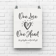 a white poster with the words one love, one heart on it against a brick wall