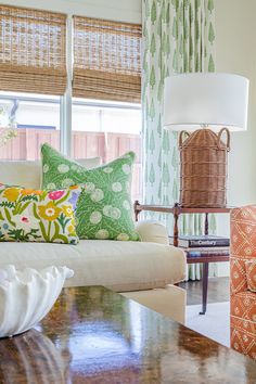 a living room filled with lots of furniture and pillows on top of a wooden table