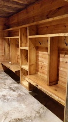 an empty room with wooden shelves and benches