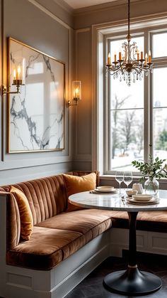 a room with a table, couch and chandelier