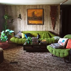 a living room filled with green couches and potted plants on top of them