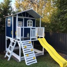 a blue and white play house with a yellow slide