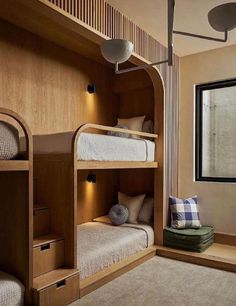 the bunk beds in this room are made from wood and have built - in shelves