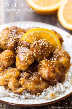 orange chicken with sesame seeds and rice on a plate