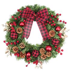 a christmas wreath with pine cones, berries and other decorations on it is hung in front of a white background