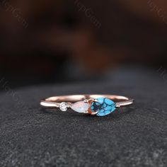 a close up view of a turquoise and white stone in a rose gold band ring