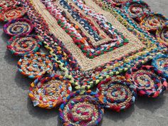 a multicolored rug is laying on the ground next to some baskets and bowls