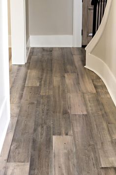 an image of a wood floor with white trim and gray stain on the bottom half