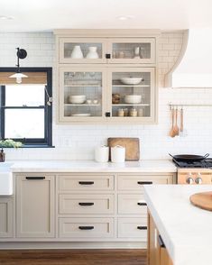 a kitchen with white cabinets and wooden floors