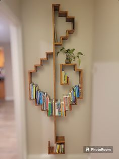 a book shelf with books on it and a plant growing out of the top one