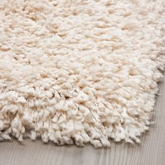 a white rug on top of a wooden floor