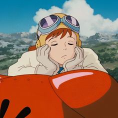 an anime character laying on the ground with her head in her hands and wearing goggles