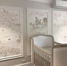 a baby crib in front of two wallpapered walls with pictures on it