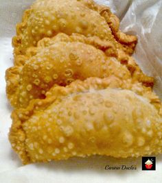 three fried food items sitting on top of white paper