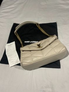 Saint Laurent LouLou Small YSL Puffer Chain Shoulder Bag Color: Crema Soft (soft white/cream with gold hardware) 100% AUTHENTICITY GUARANTEED!! Comes with original dust bag and receipt!! Purchased at Neiman Marcus in 09/2022 Original Retail Value: $2850.00 USD (now retails for $3200.00 USD) Saint Laurent "LouLou" shoulder bag in matelassé quilted leather. ~Sliding leather/chain shoulder strap can be doubled, 11"-20" drop. ~Flap top with metal YSL monogram; snap closure. ~Golden hardware. ~Interior, one main compartment, one zip pocket. ~Grosgrain lining. ~6.7"H x 11.4"W x 4.3"D. ~Approx. weight 1.6 lb. ~Made in Italy. Blanc Vintage Ysl Bag, Ysl Puffer, Slouchy Bag, Saint Laurent Handbags, Clutches For Women, Color Crema, Women Midi, Boho Bag, Chain Shoulder Bag