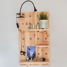 a wooden shelf with two shelves and a potted plant next to it on the wall