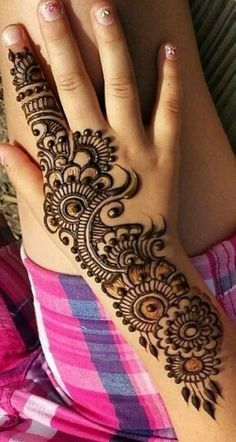 a woman's hand with henna tattoos on it