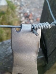 a piece of metal hanging from a wire