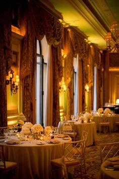 a banquet room with tables and chairs set up for formal dinnereons in the evening