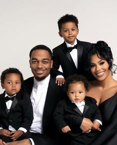 the family is posing for a photo in their tuxedo suits and bow ties