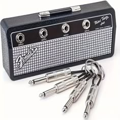 four keys are in front of a black and white amplifier with five smaller ones attached to it