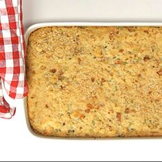 a casserole dish is shown with a red and white checkered cloth next to it