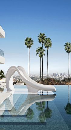 an outdoor swimming pool with water slide and palm trees in the background