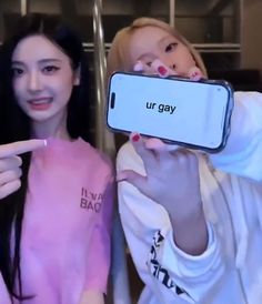 two girls are holding up their cell phones to show off the same text on them