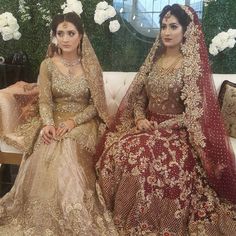 two brides sitting on a couch in matching outfits