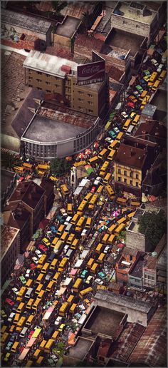 an aerial view of a city street with lots of cars and buses parked in it