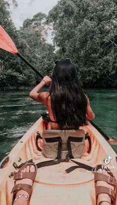 a woman in a kayak paddling down the river